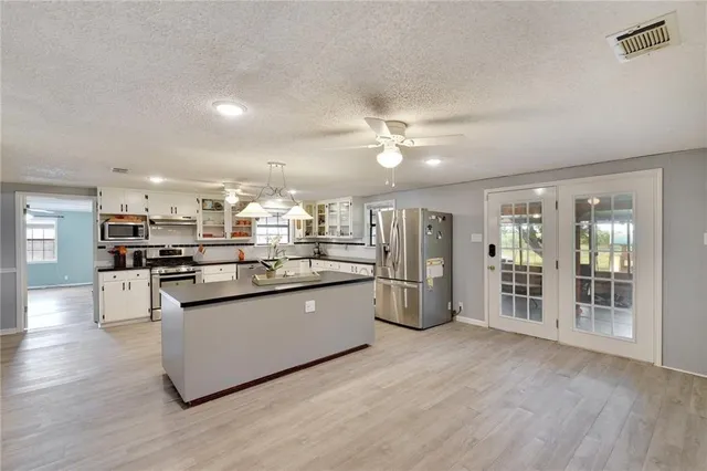 a kitchen with stainless steel appliances granite countertop a refrigerator and a stove top oven