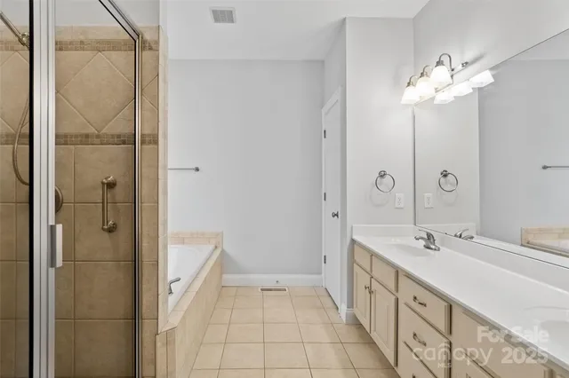 a spacious bathroom with a double vanity sink a large mirror and shower