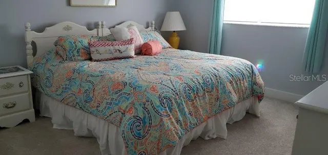 a bed sitting in a bedroom next to a window