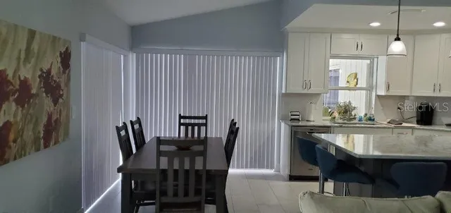 a kitchen with a table chairs sink and cabinets