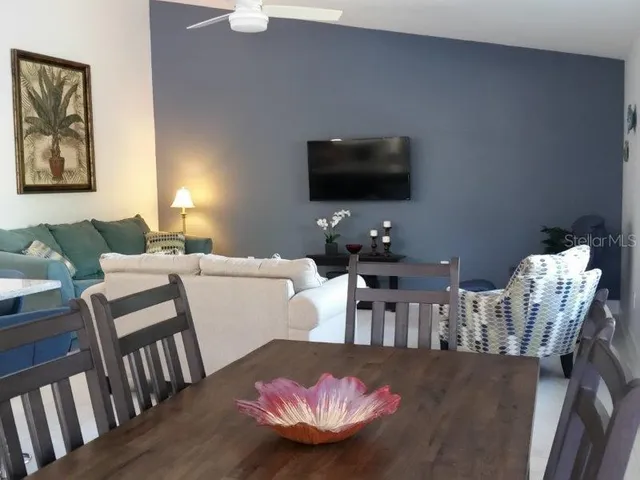 a living room with furniture a flat screen tv and kitchen view