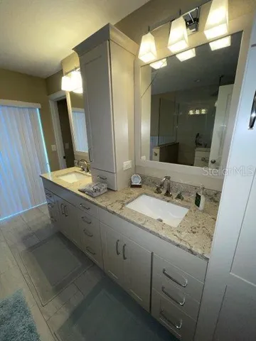 a bathroom with a double vanity sink and a mirror