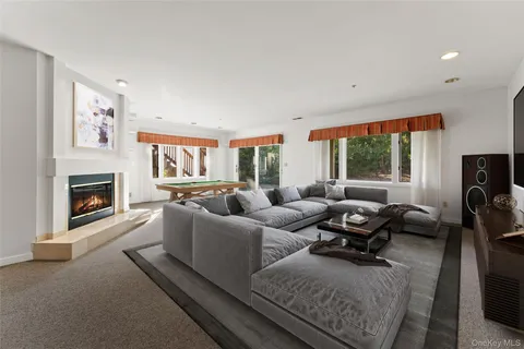 a living room with furniture fireplace and a large window