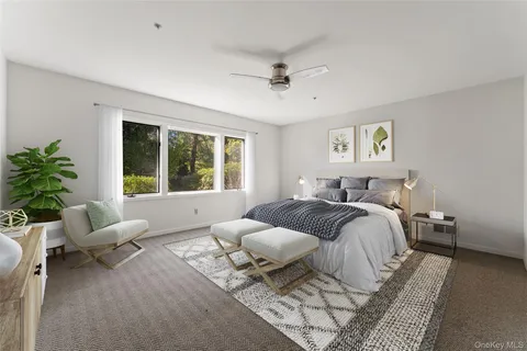 a spacious bedroom with a bed a couch and potted plant with the outer view