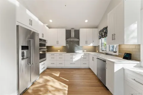 a kitchen with stainless steel appliances kitchen island granite countertop a refrigerator and a sink