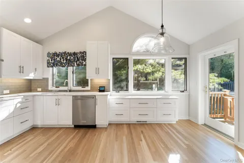 a large white kitchen with a large window