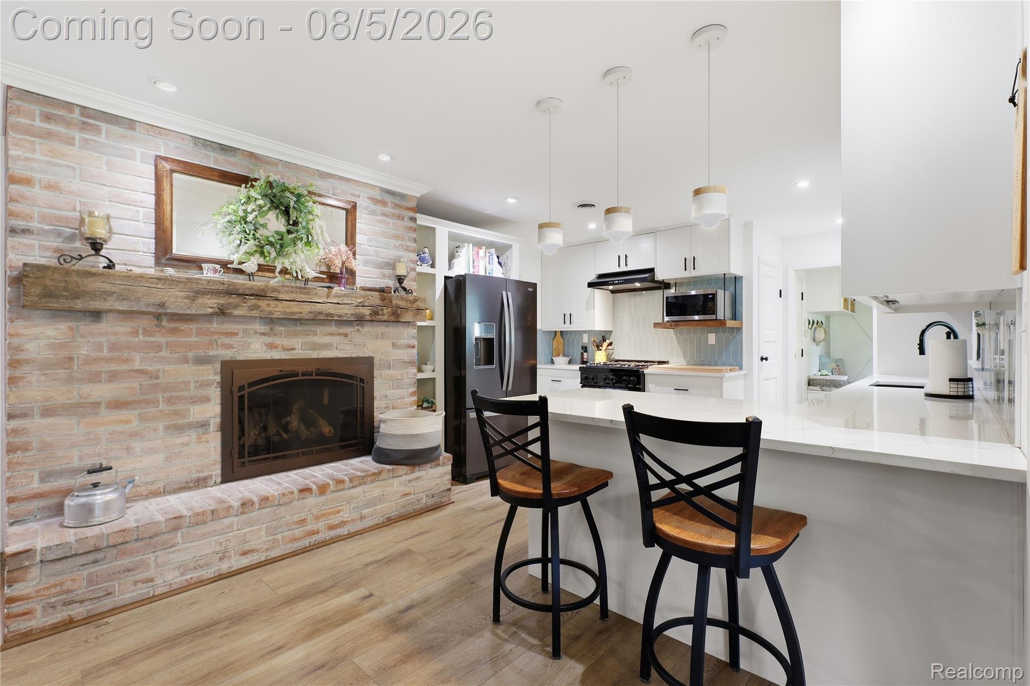 6478 West Stanley Road Mount Morris, MI 48458 - Photo 28 of 80 Open-concept kitchen and living area featuring a brick-front fireplace with a distressed wood mantel