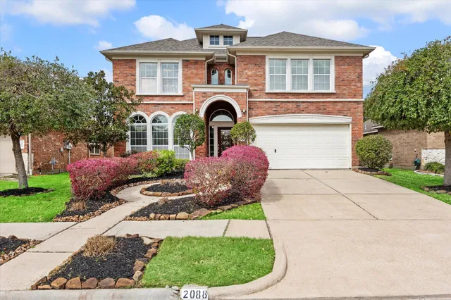 a front view of a house with a garden and plants