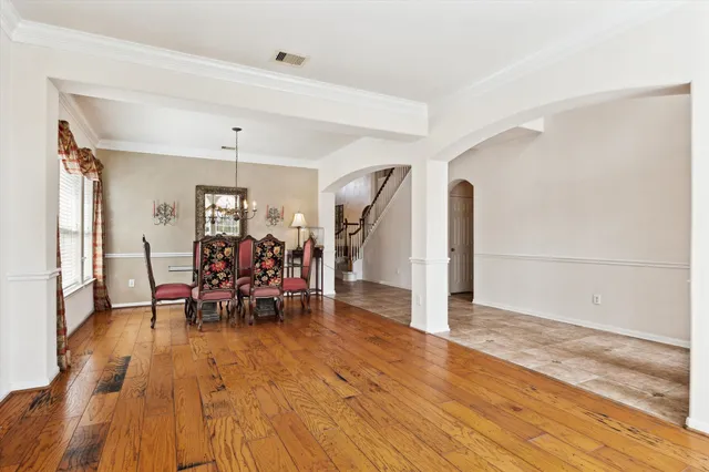 a view of a room with wooden floor furniture and a chandelier
