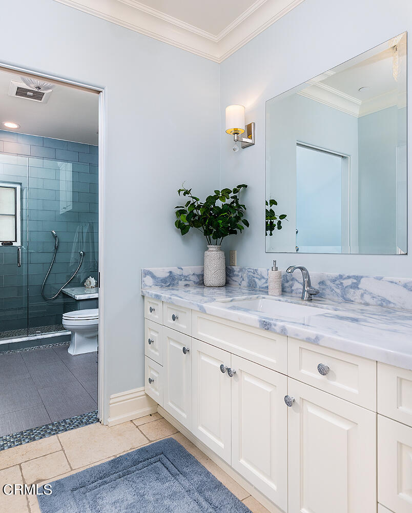 1610 Kinneloa Mesa Road Pasadena, CA 91107 - Photo 42 of 72 a bathroom with a granite countertop sink a toilet and a shower
