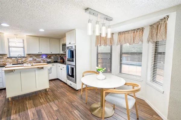 a kitchen with a table chairs sink and cabinets
