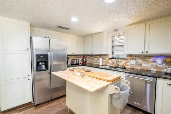 a kitchen with a refrigerator a sink and cabinets