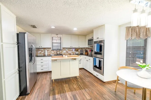 a kitchen with white cabinets and stainless steel appliances