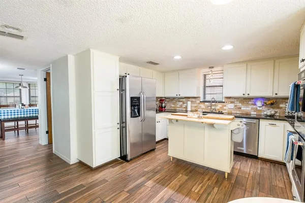 a kitchen with white cabinets and white appliances