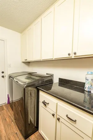 a kitchen with granite countertop a stove and white cabinets