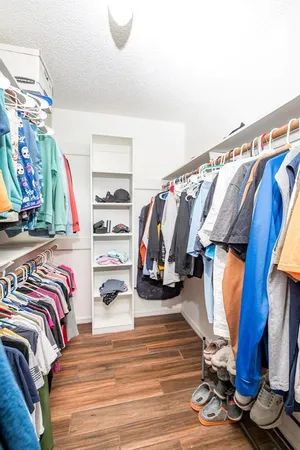 a view of walk in closet with clothes and shoes