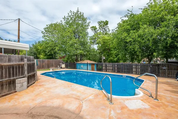 a view of a backyard with swimming pool