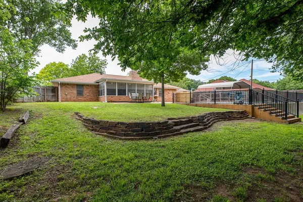 a front view of a house with a garden and trees