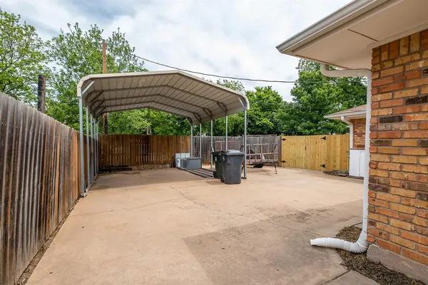 a view of backyard with wooden fence and trees