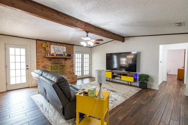 a living room with furniture and a flat screen tv with wooden floor