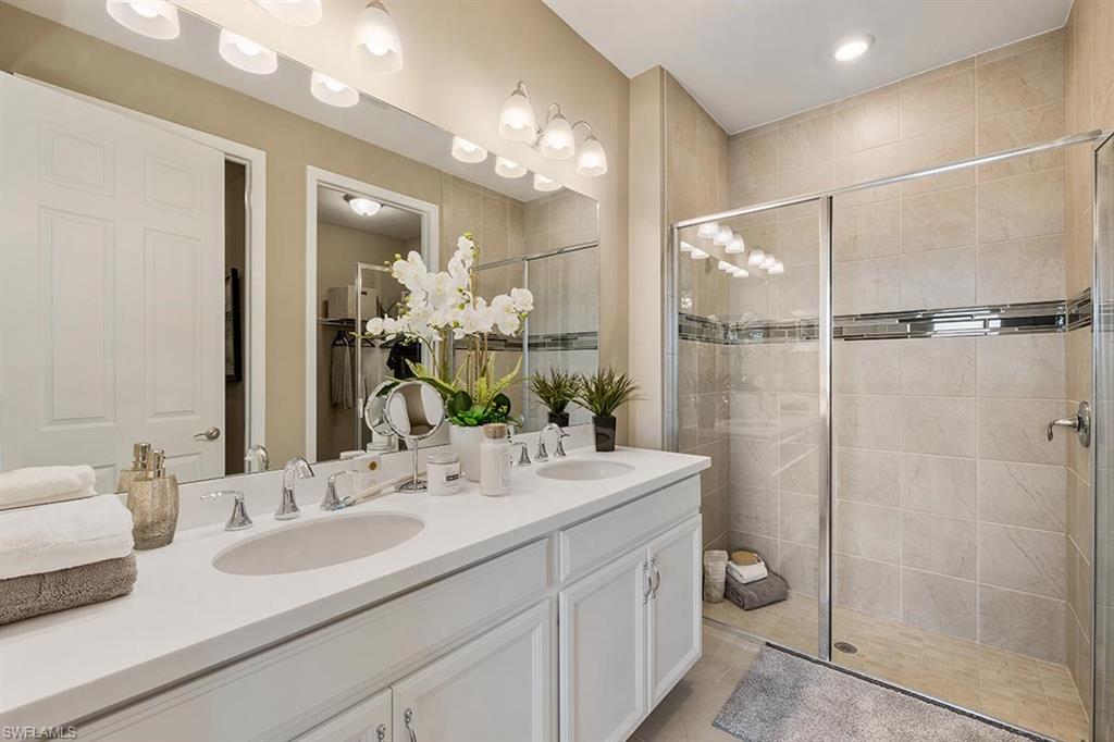 1067 Enbrook Loop Naples, FL 34114 - Photo 11 of 15 a bathroom with a double vanity sink mirror and shower