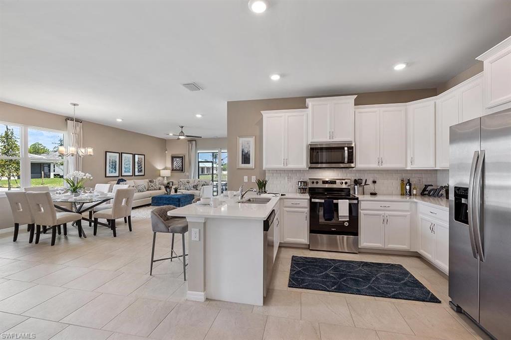 1067 Enbrook Loop Naples, FL 34114 - Photo 3 of 15 a kitchen with cabinets and stainless steel appliances