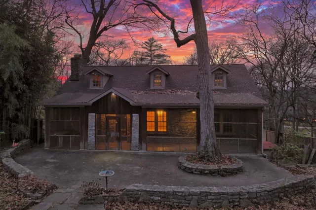 a front view of a house with a tree