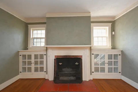 a view of a hallway with wooden floor and a window