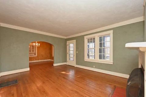 a large kitchen with a wooden floor and a refrigerator