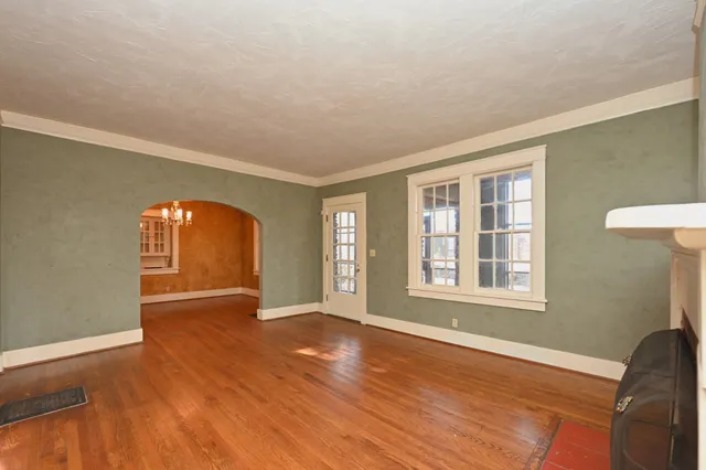 a large kitchen with a wooden floor and a refrigerator