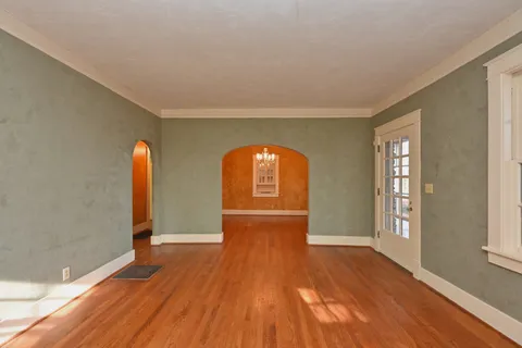 a large kitchen with a wooden floor and a refrigerator