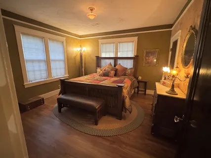 a view of an empty room with wooden floor and stairs