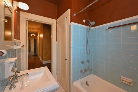 a bathroom with a tub sink and mirror