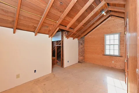 a view of backyard with small cabin and wooden fencing