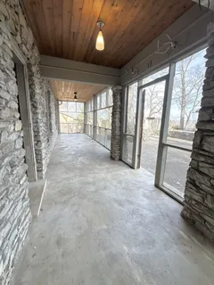 an empty room with wooden floor cabinet and windows