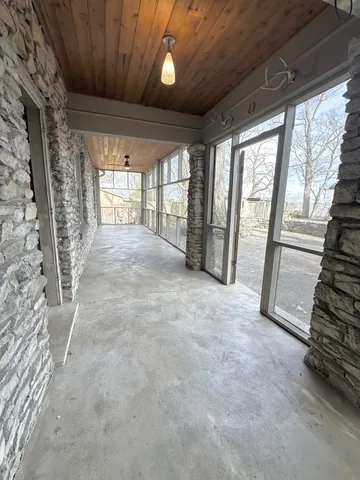 an empty room with wooden floor cabinet and windows