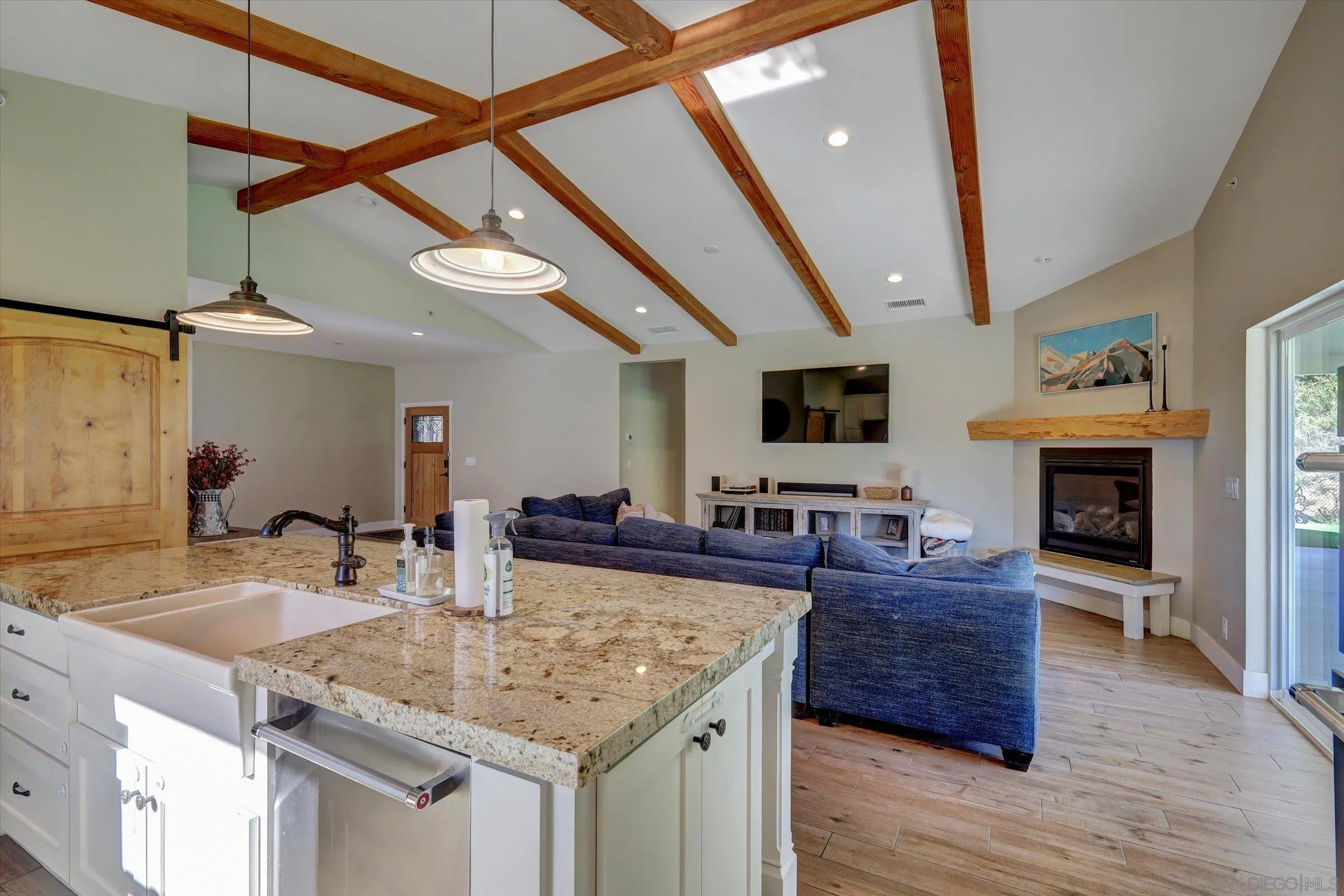 11611 Rancho Heights Road Pala, CA 92059 - Photo 7 of 43 a kitchen with stainless steel appliances granite countertop a sink dishwasher and a fireplace with wooden floor