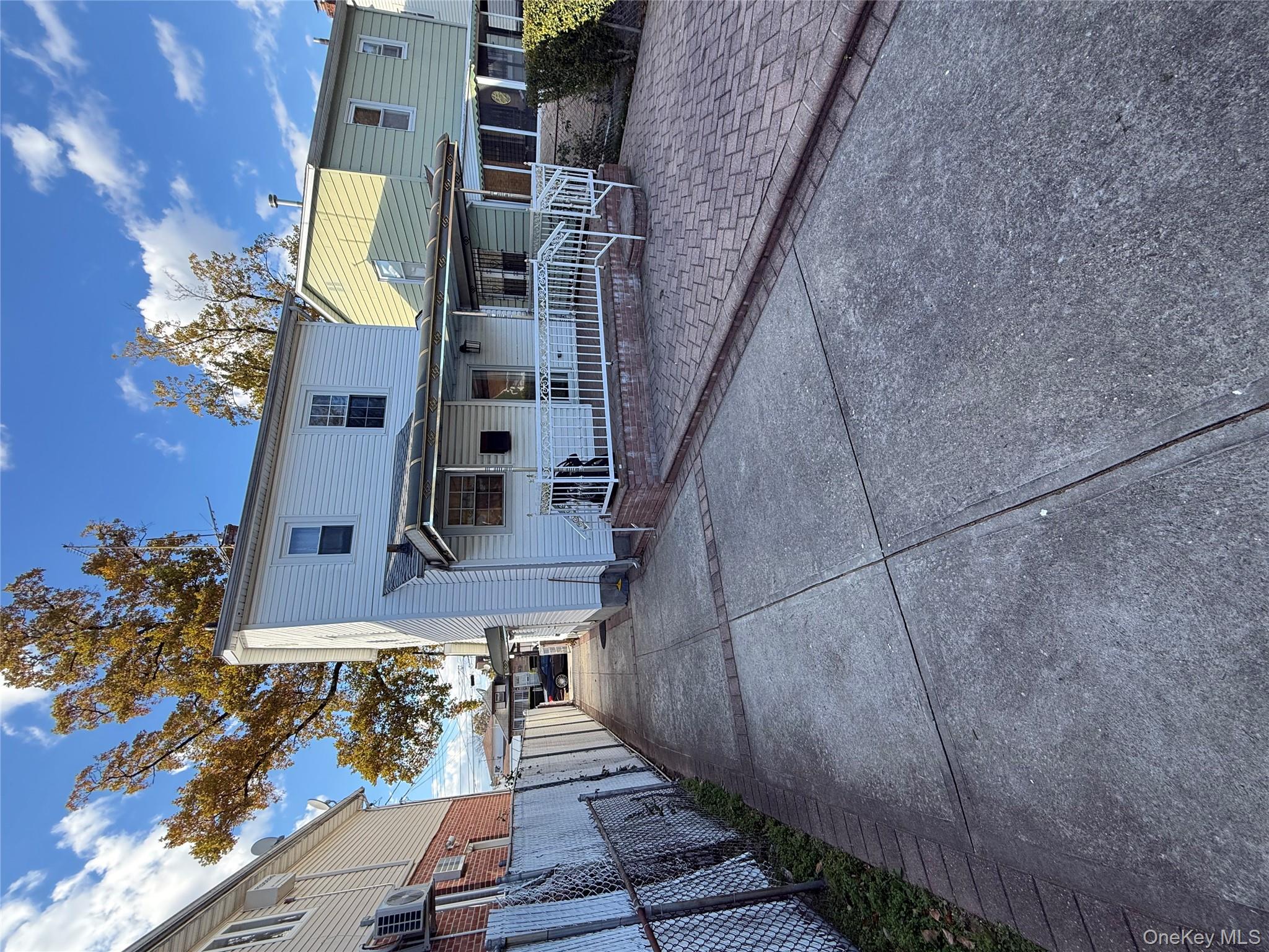 136-29 220th Place Queens, NY 11413 - Photo 13 of 45 Back of property featuring concrete driveway and a patio