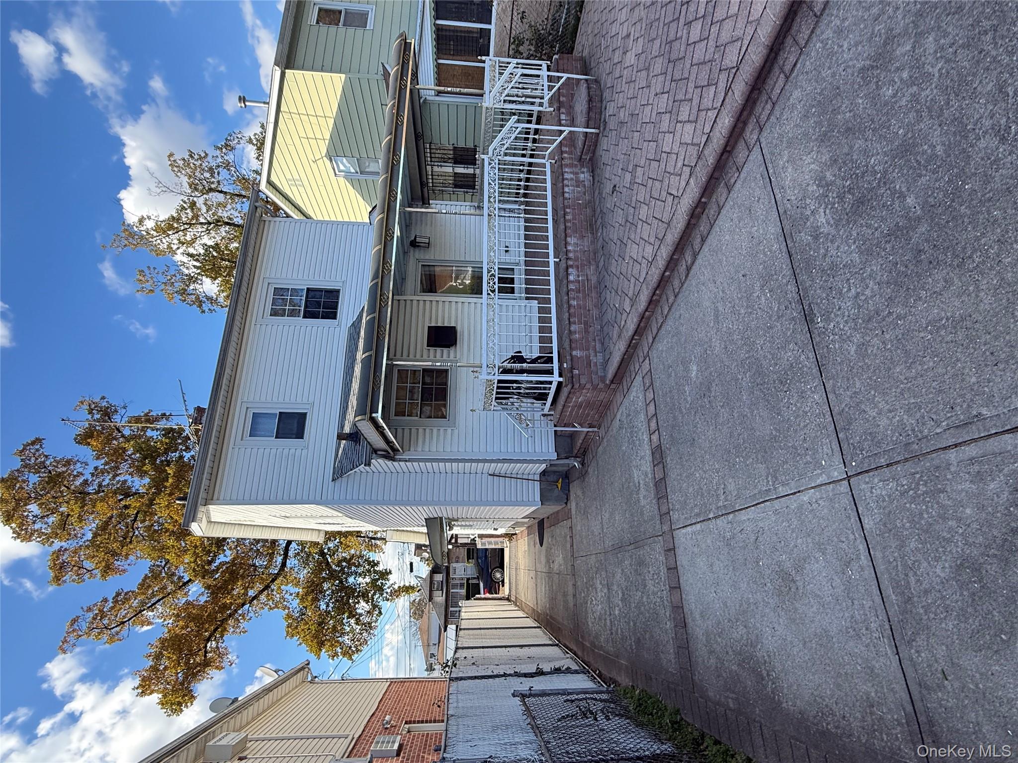136-29 220th Place Queens, NY 11413 - Photo 14 of 45 Rear view of property featuring driveway