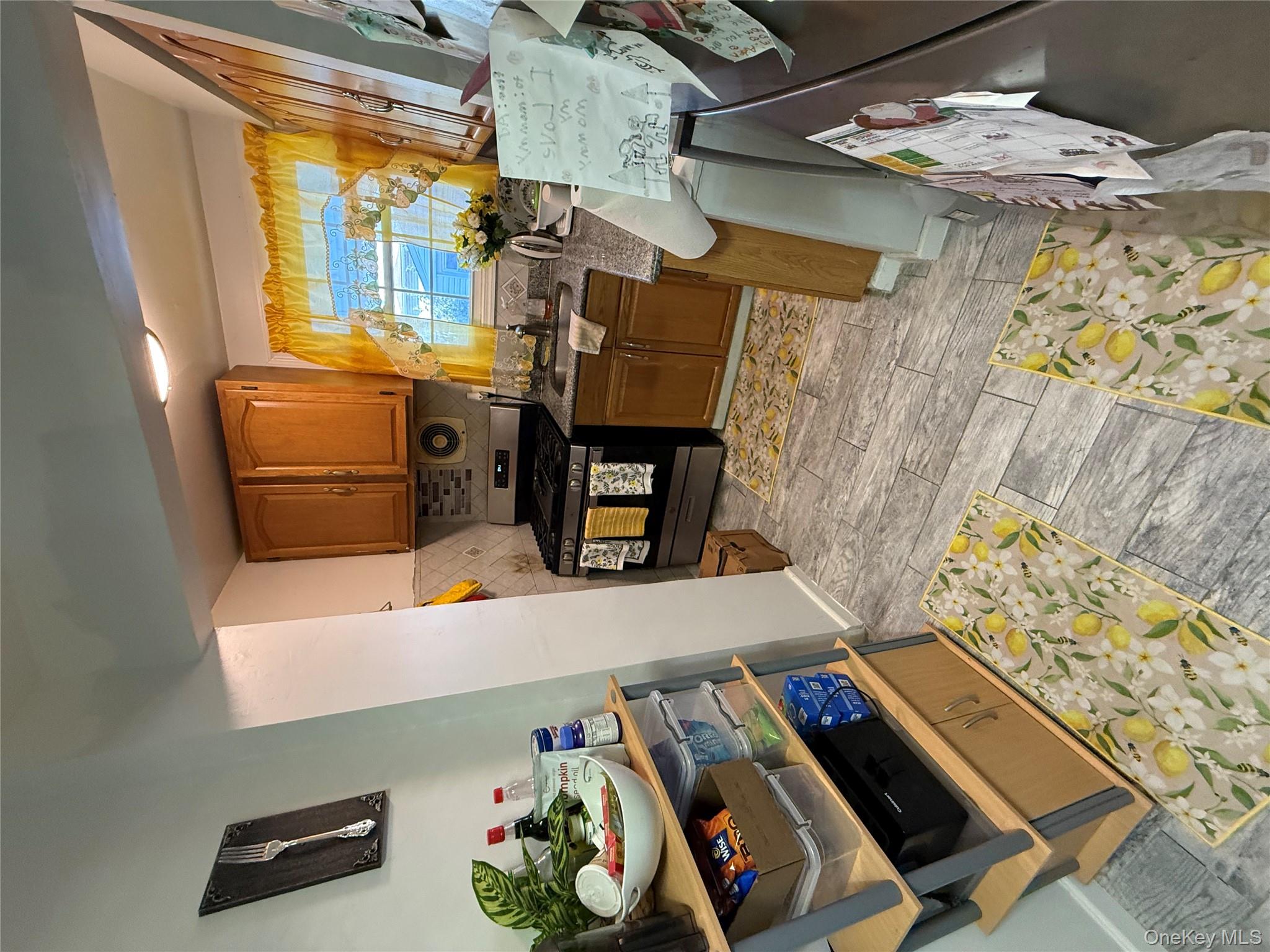 136-29 220th Place Queens, NY 11413 - Photo 18 of 45 Kitchen featuring brown cabinets, decorative backsplash, wood finish floors, and stainless steel gas range