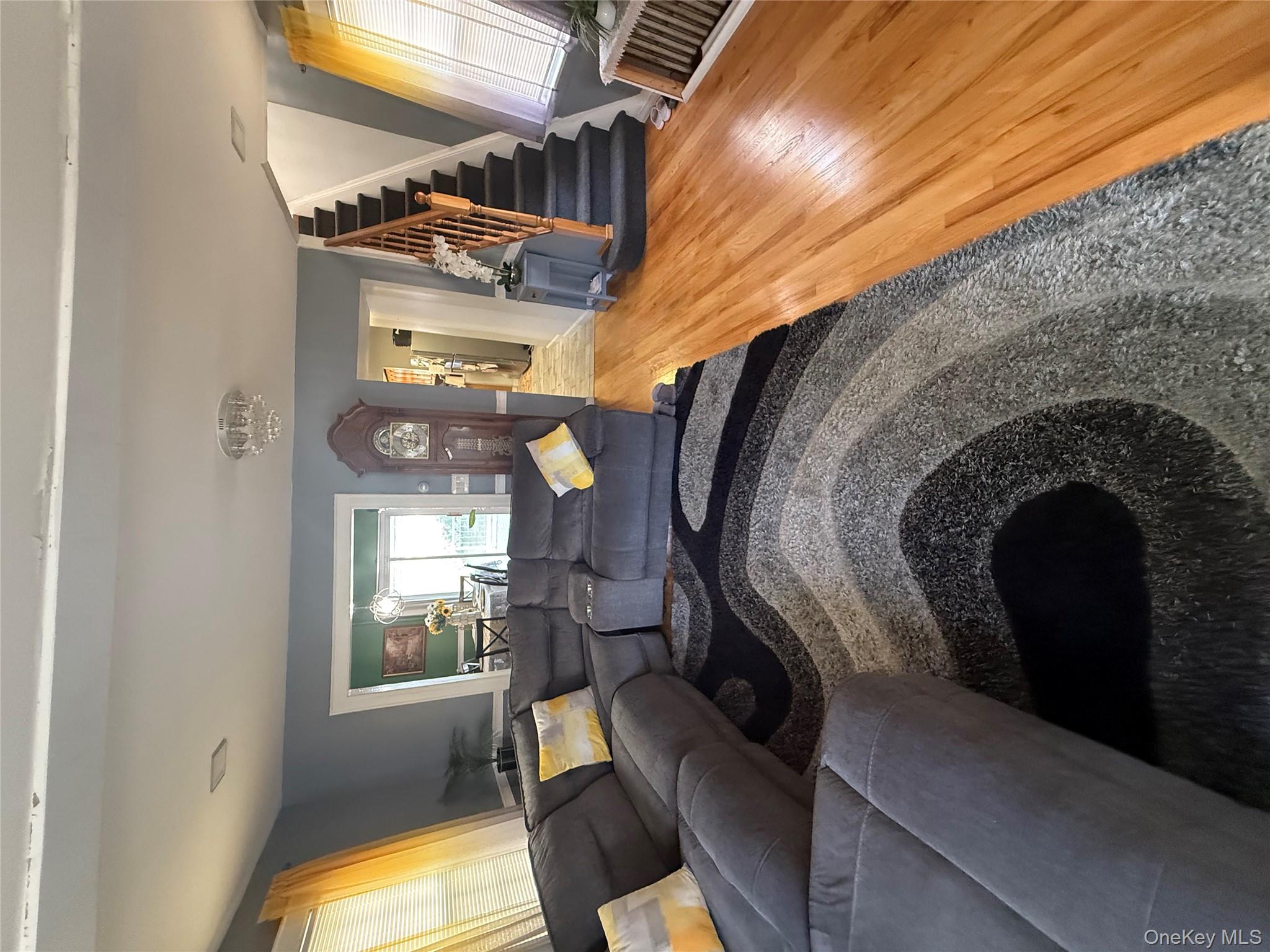 136-29 220th Place Queens, NY 11413 - Photo 23 of 45 Living area featuring wood finished floors, stairs, and a chandelier