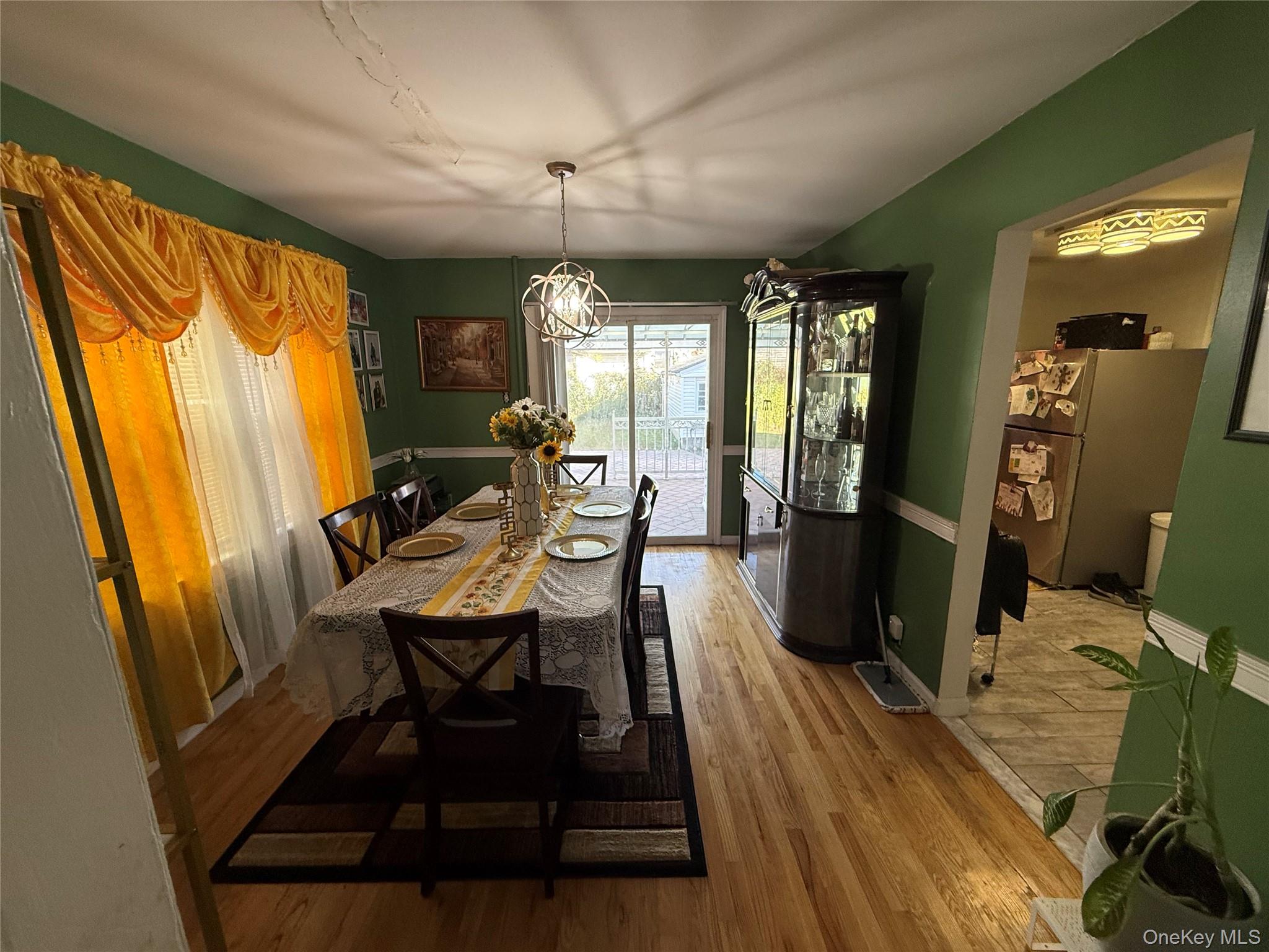 136-29 220th Place Queens, NY 11413 - Photo 31 of 45 Dining space featuring wood finished floors and a chandelier