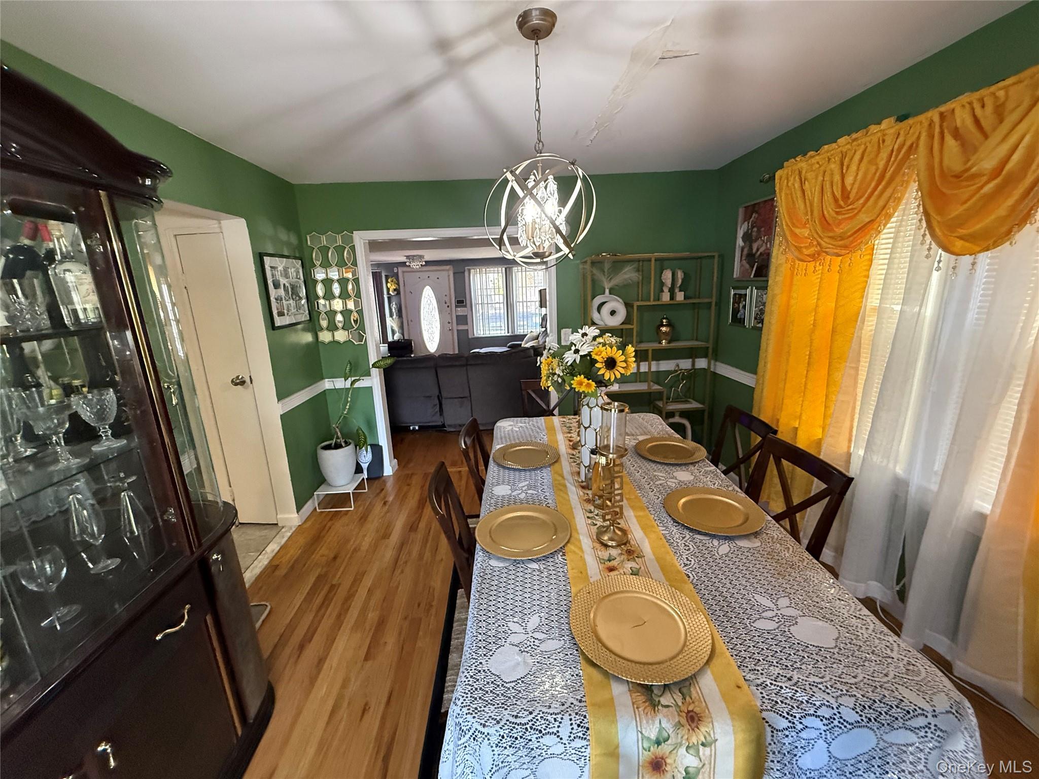 136-29 220th Place Queens, NY 11413 - Photo 32 of 45 Dining room featuring wood finished floors and a chandelier