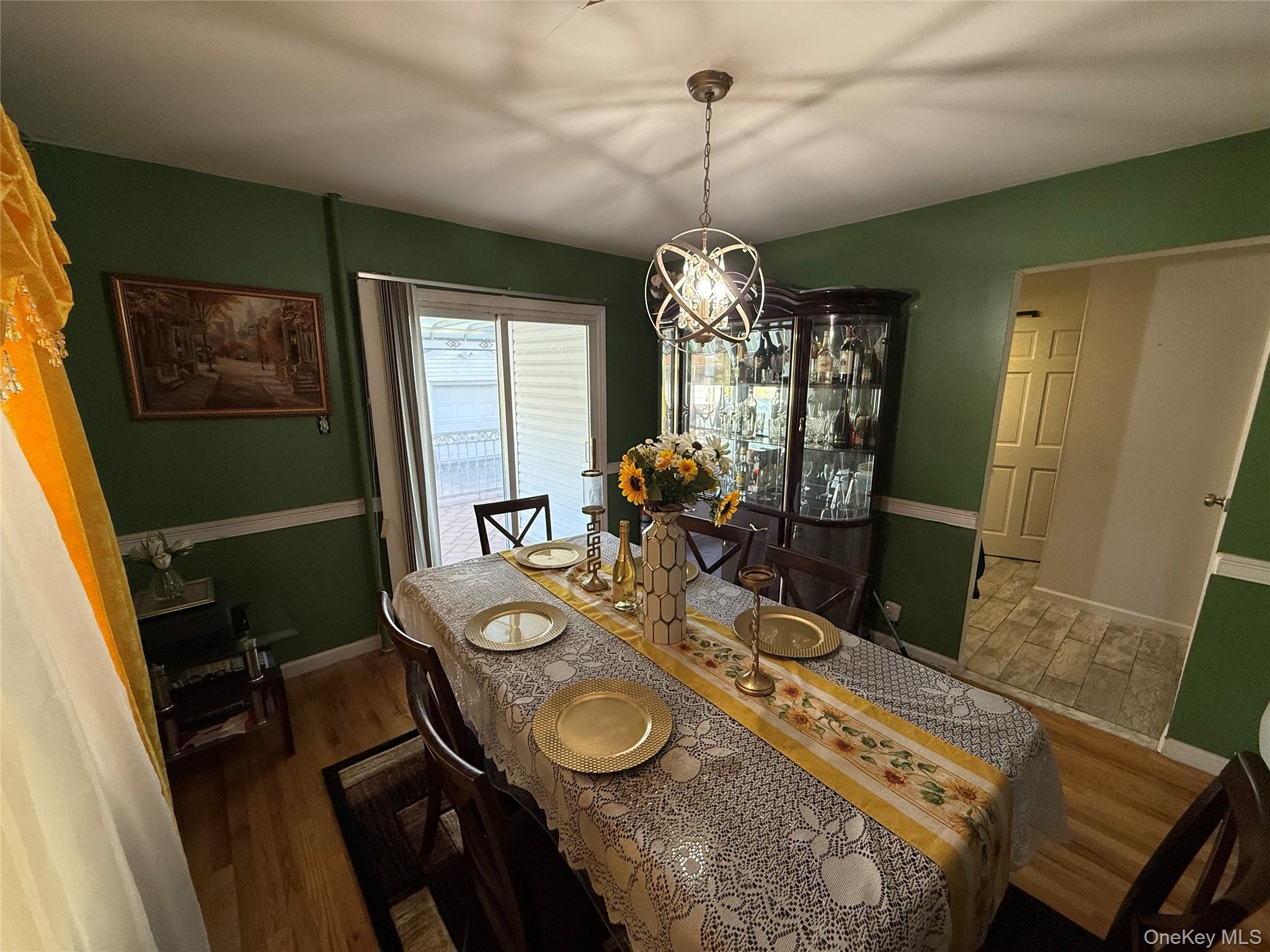 136-29 220th Place Queens, NY 11413 - Photo 33 of 45 Dining space featuring dark wood-style flooring and a chandelier