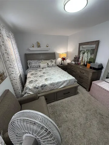 a bedroom with bed and wooden floor