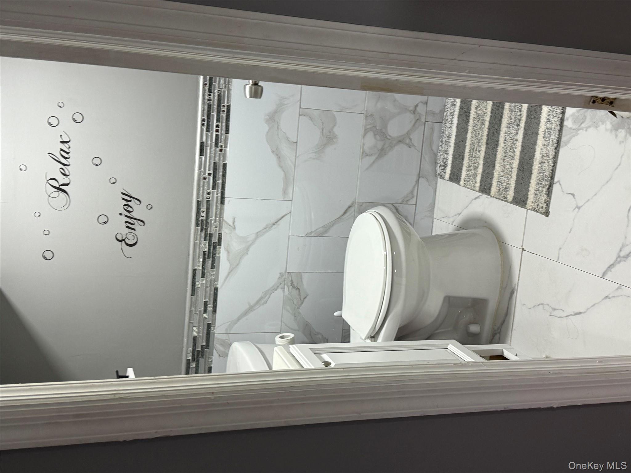 136-29 220th Place Queens, NY 11413 - Photo 40 of 45 Bathroom featuring light marble finish flooring and tile walls