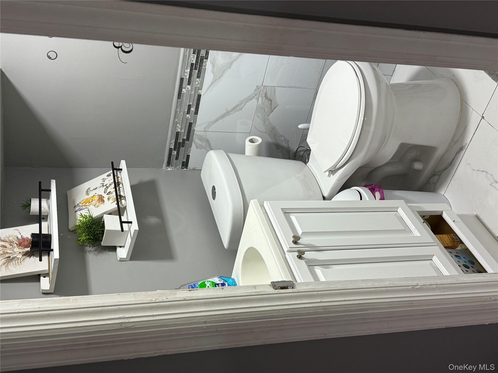 136-29 220th Place Queens, NY 11413 - Photo 41 of 45 Bathroom with vanity, light marble finish flooring, and tile walls