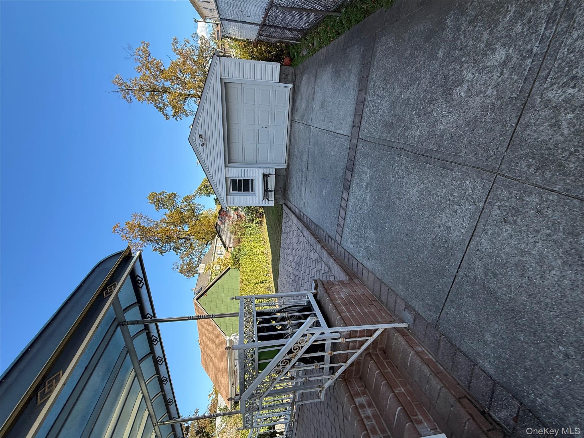 136-29 220th Place Queens, NY 11413 - Photo 6 of 45 Detached garage featuring concrete driveway