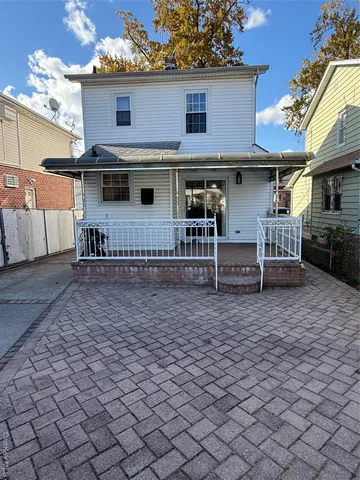 a view of a house with wooden deck and furniture