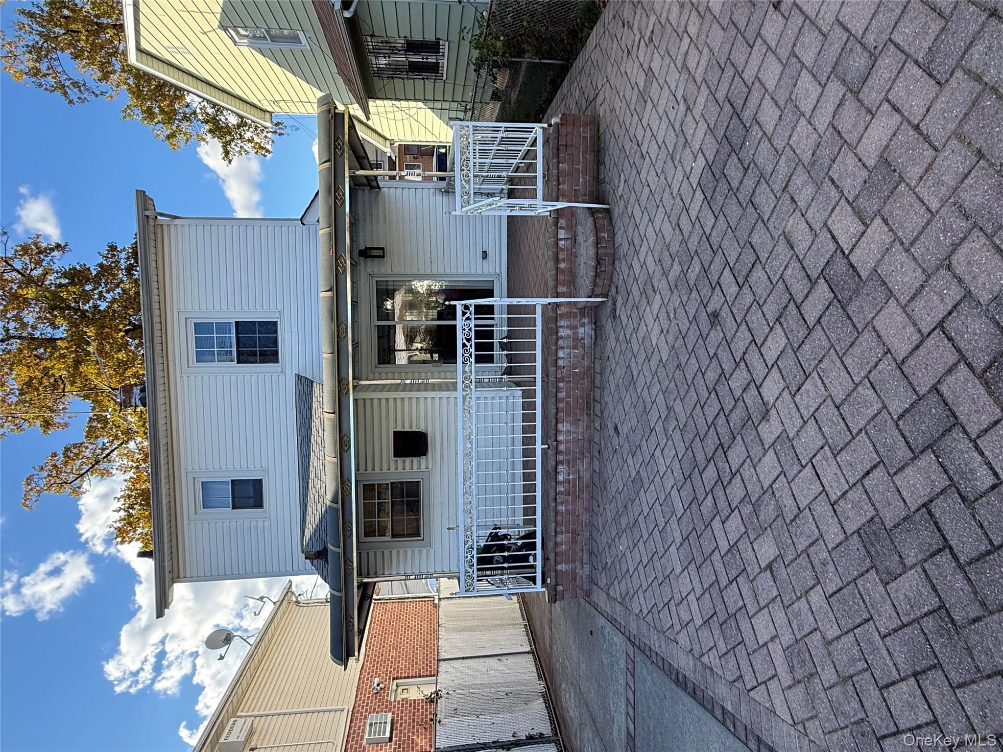 136-29 220th Place Queens, NY 11413 - Photo 10 of 45 Rear view of house featuring a wooden deck and a patio area